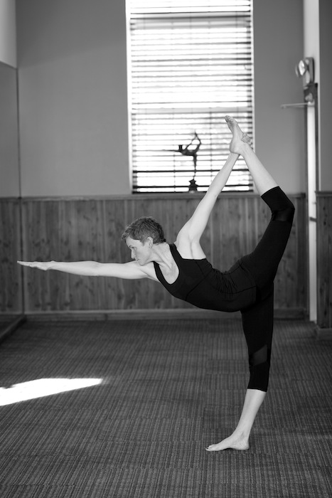 Young Indian girl doing Yoga . Dandayamana Dhanurasana (Standing Bow  Pulling Pose) Mountain backdrop Pune, Maharashtra. - SuperStock